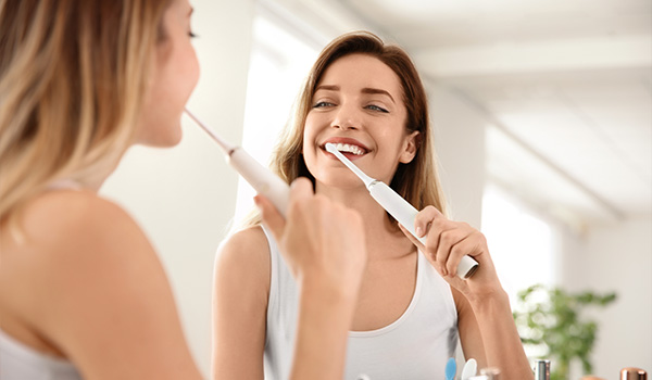 close up of a smiling woman showcasing white teeth and healthy gums with a bright expression highlighting the importance of dental care and hygiene for a confident smile 2 ways to improve oral health